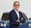 Der neue Vorstand für das Ressort Car-IT Sajjad Khan vor einem Porsche.