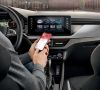 Ein Fahrer nutzt die Škoda Connect-App in seinem Fahrzeug