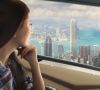 Eine Frau schaut aus einem Flugtaxi auf die Skyline einer Stadt.