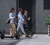 Drei Menschen mit E-Roller, Fahrrad und Fußgänger / Die Mobilität steht im Zeichen der Super-Apps