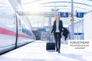 Eine Frau läuft mit einem Rollkoffer am Bahnsteig neben einem Zug der Deutschen Bahn.