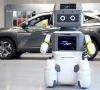 Der DAL-e-Roboter steht vor einem Hyundai-Fahrzeug in einem Verkaufsraum.