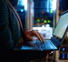 IT-Mitarbeiter mit Laptop vor Server / Autobranche: IT-Abteilungen müssen den Gürtel enger schnallen