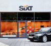 Ein BMW steht vor einer Mietwagen-Station von Sixt