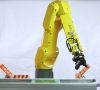 Ein Roboterarm bestückt Leiterplatten in der Industrie