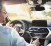 Der Fahrer eines BMWs nutzt die Sprachsteuerung seines Infotainment-Systems.